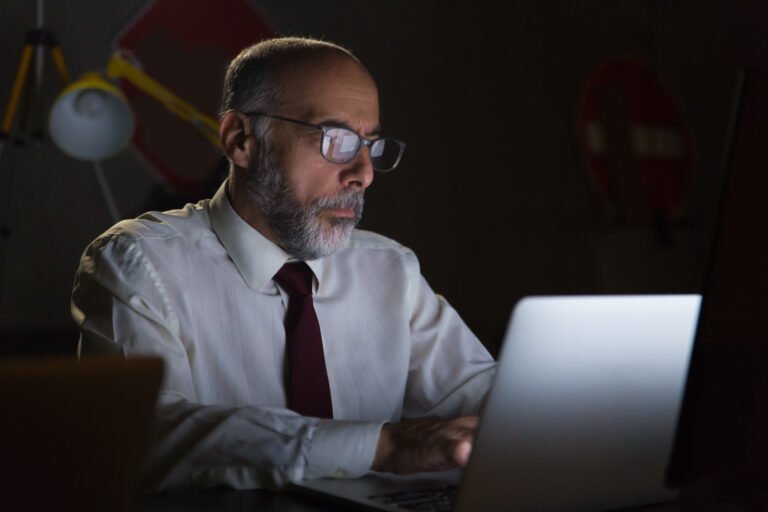 Businessman using laptop in dark office